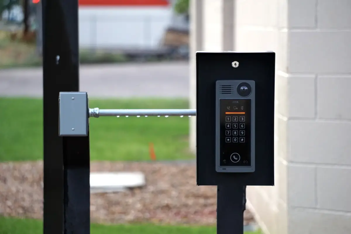 Keypad on a pedestal beside a driveway entry gate