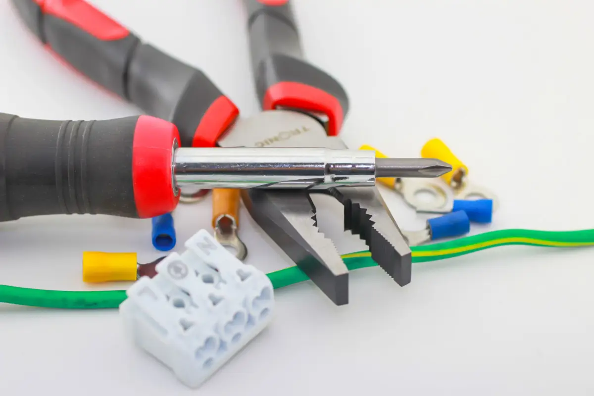 Wire strippers, ferrules and terminal blocks laid out for wiring a gate operator control circuit