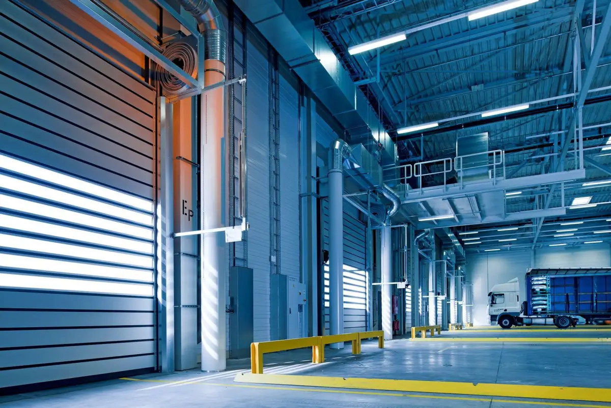 Row of commercial loading dock doors inside a warehouse with a truck parked at the far bay