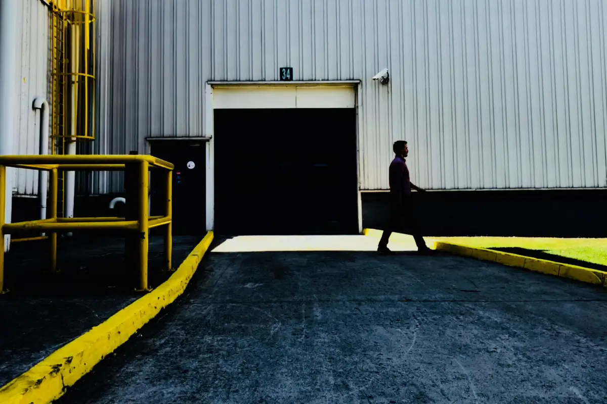 Industrial building loading area with a yellow guardrail and secured overhead door