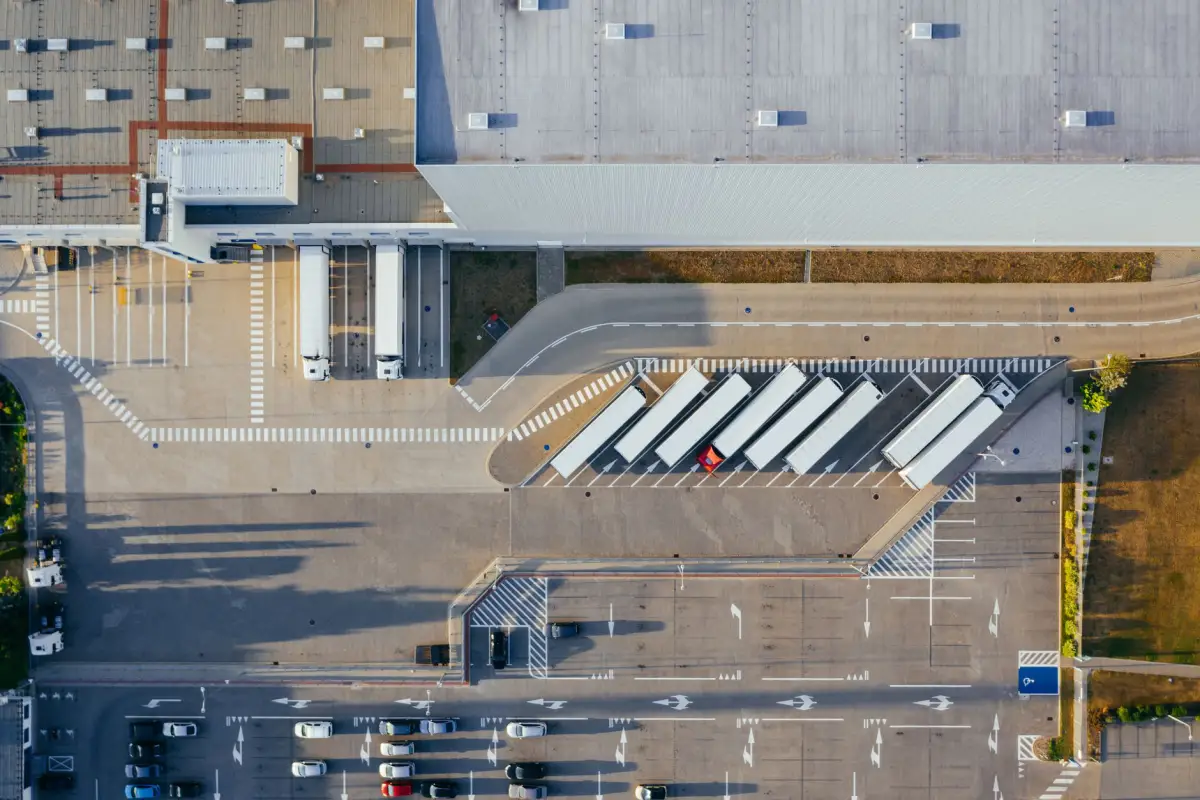 Aerial view of a trucking terminal with trailers at the docks and a single controlled access route