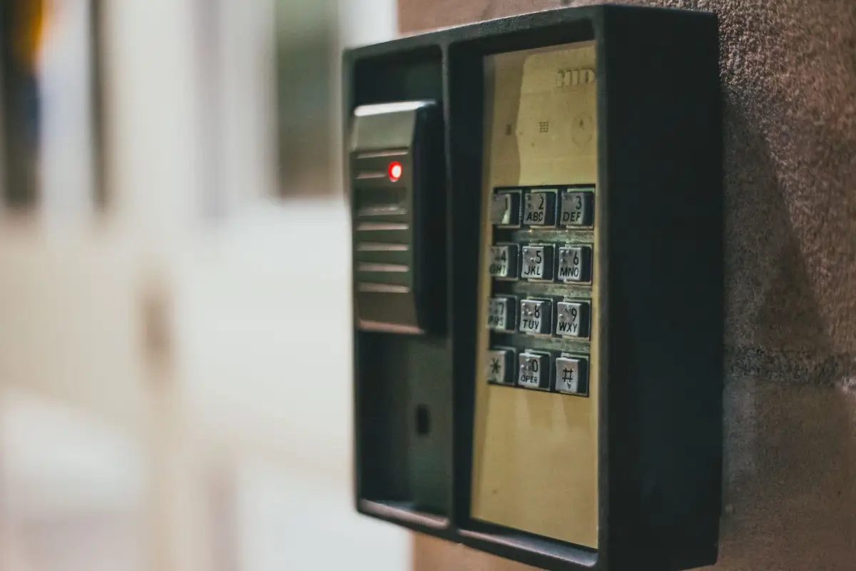 Close-up of a weatherproof gate entry keypad and intercom unit mounted on a wall