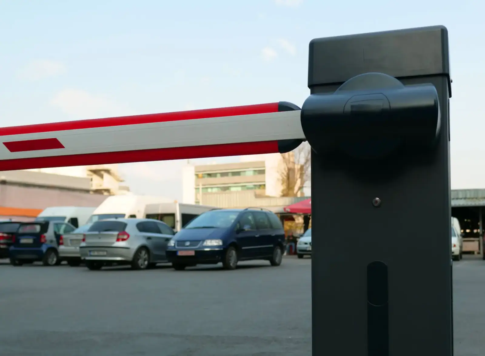 Automatic barrier arm and operator housing at the vehicle entrance to a parking area