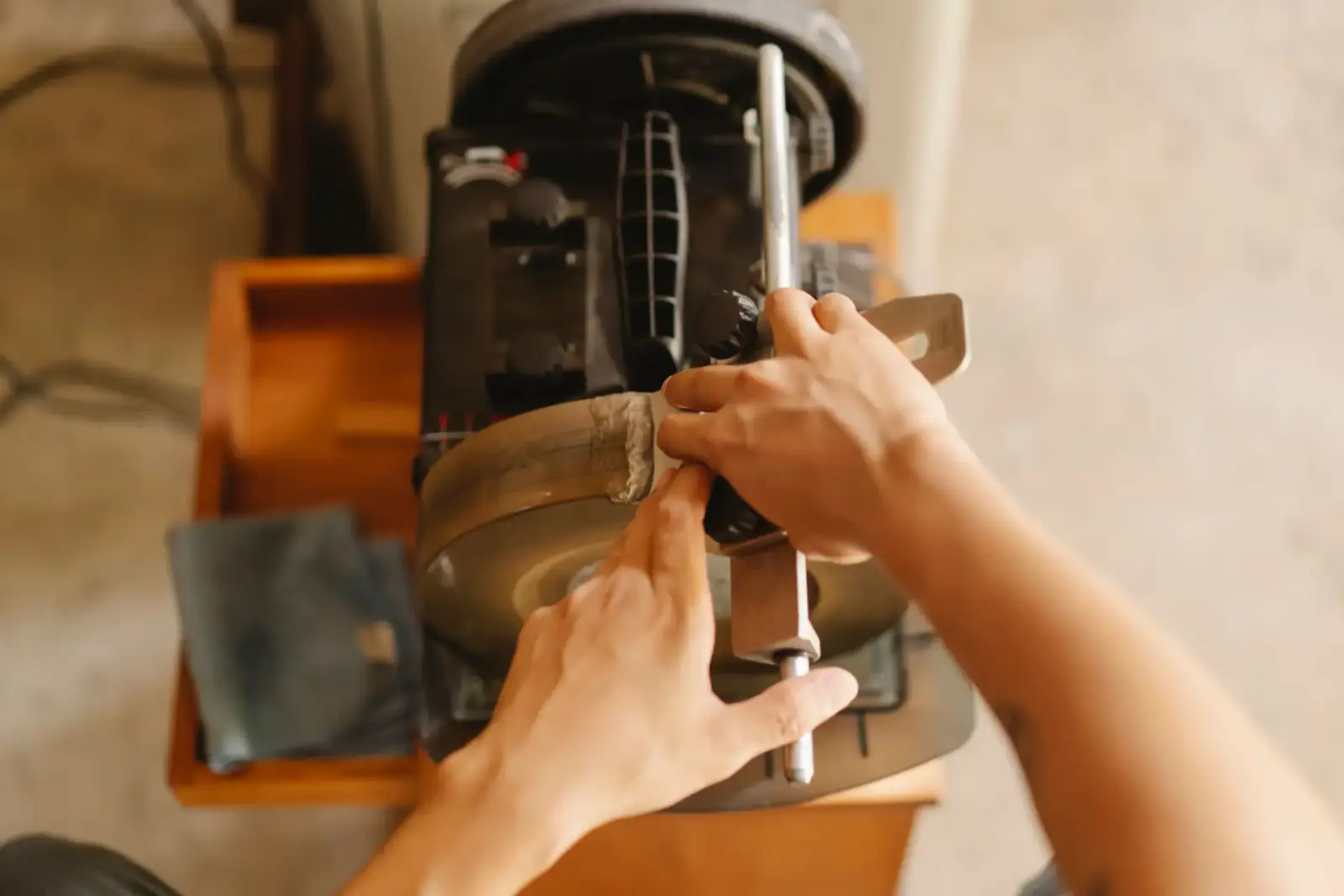 Hands adjusting the housing and shaft of an electric gate operator motor on a workbench