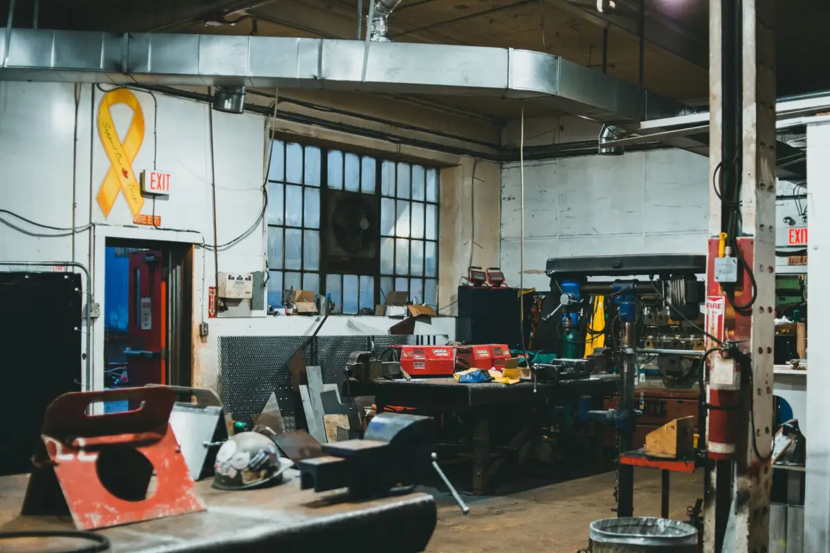 Interior of a metal fabrication shop with steel stock, benches and heavy equipment