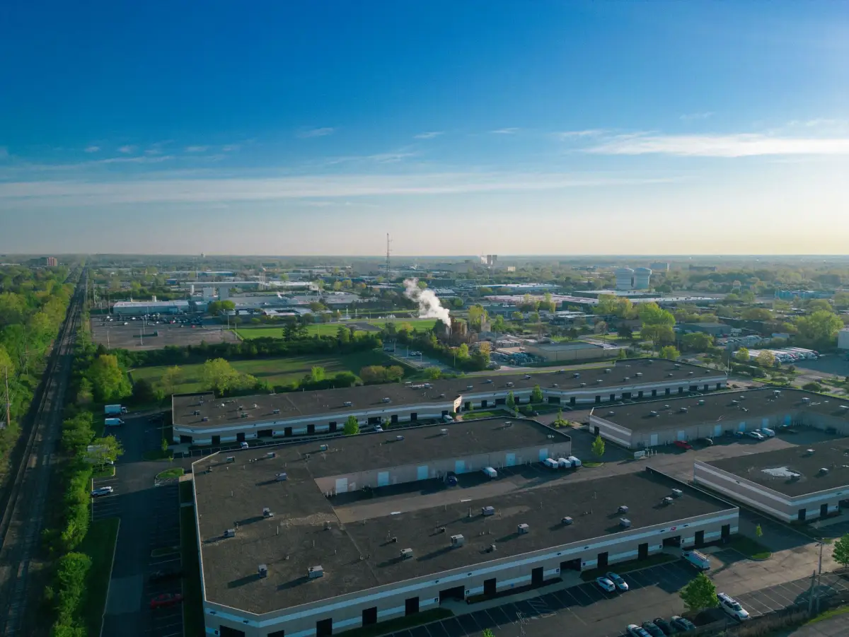 Aerial view of an industrial park with warehouse buildings and fenced vehicle access yards